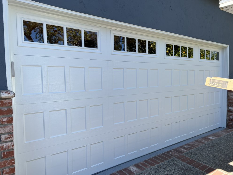 White carriage-style garage door with panel windows